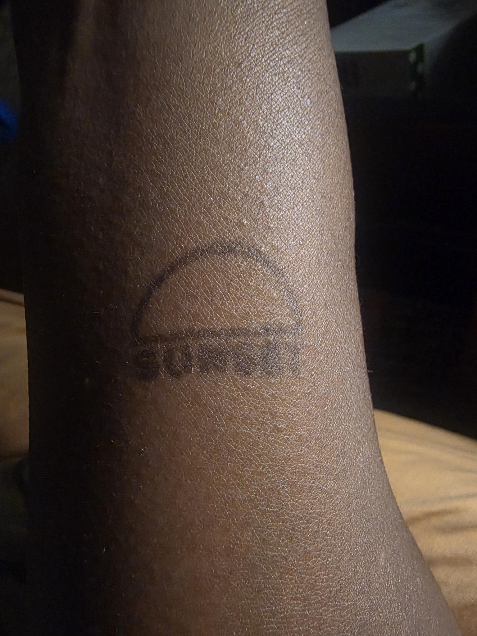 the word sunset stamped on an arm